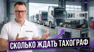 Мастер занимается установкой тахографа в кабине коммерческого грузового автомобиля.